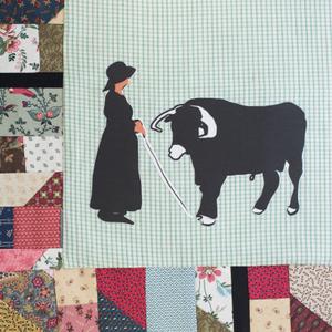 A silhouette of a woman and a cow.