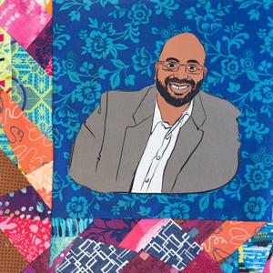 Adrian Miller smiling in a suit jacket.