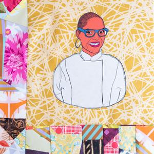 Tanya Holland smiling in a white chef coat.