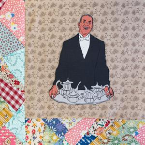 Alfonzo Fields smiling and holding a tray with a tea set.