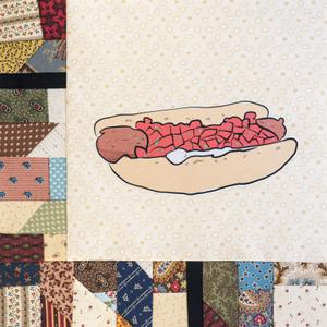 A hotdog with white sauce and red topping.