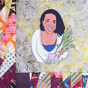 Toni Tipton Martin smiling and holding vegetables in her hand.