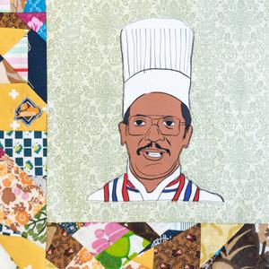 Clifton Williams smiling and wearing glasses and a white chef coat and hat.
